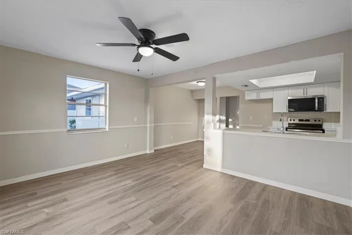 Unfurnished living room featuring light wood-type flooring and a ceiling fan