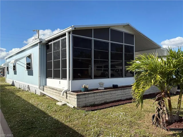 View of side of property with a lawn
