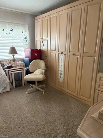 Living area with carpet floors and ornamental molding