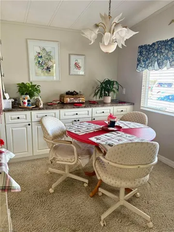 Dining space with a chandelier and light colored carpet