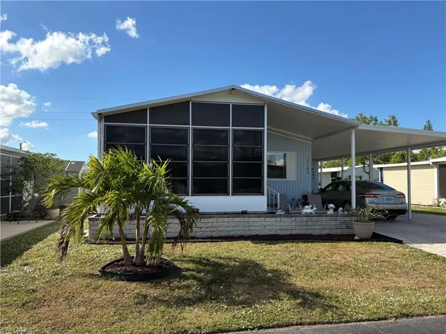 View of front of property featuring a front yard and a carport