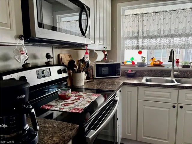 Kitchen featuring white cabinets and appliances with stainless steel finishes
