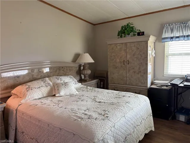 Bedroom featuring hardwood / wood-style flooring and ornamental molding