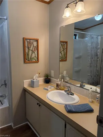 Bathroom featuring vanity, hardwood / wood-style flooring, and shower / tub combo with curtain