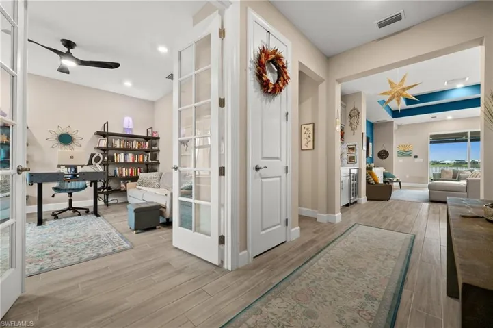 Corridor with a desk, light wood-look tile floors, french doors, and recessed lighting