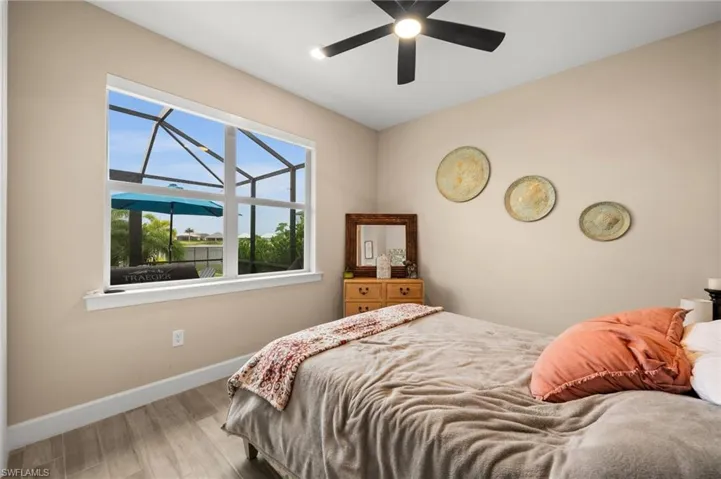 Bedroom with wood-look tile floors and ceiling fan