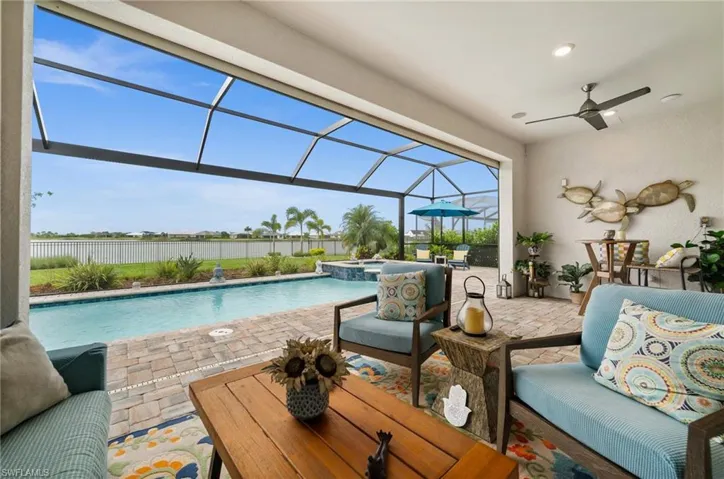 View of pool with a patio area, a lanai, a pool with connected hot tub, and a ceiling fan