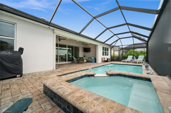 View of pool with ceiling fan, a patio, a pool with connected hot tub, and a lanai