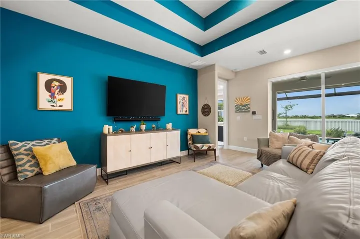 Living room featuring wood-look tile floors, a tray ceiling, and recessed lighting