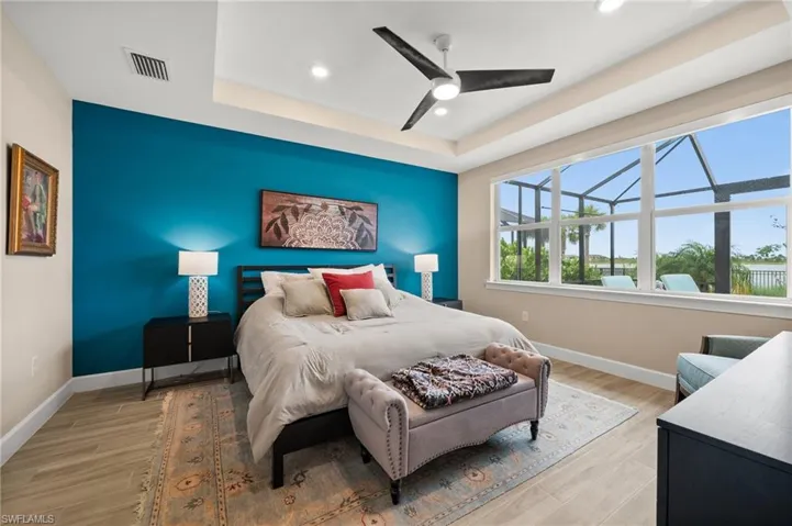 Bedroom with recessed lighting, a raised ceiling, light wood-look tile floors, and ceiling fan