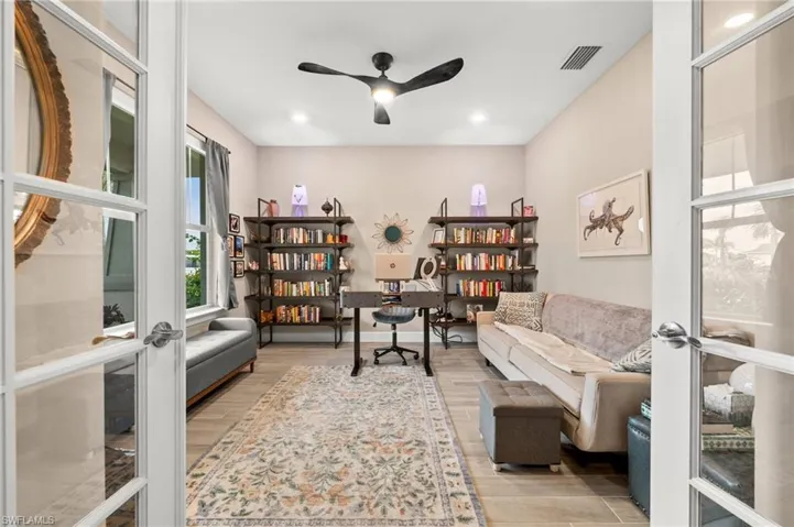 Office area with light wood-look tile floors, ceiling fan, and recessed lighting