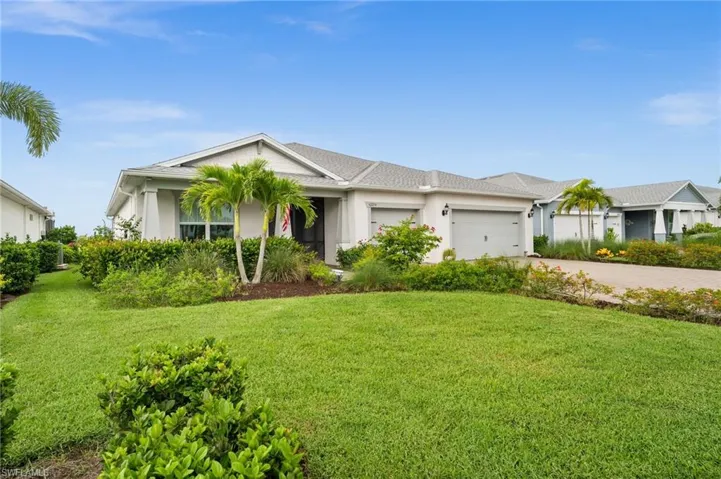 View of front facade with a garage, driveway, and a front lawn