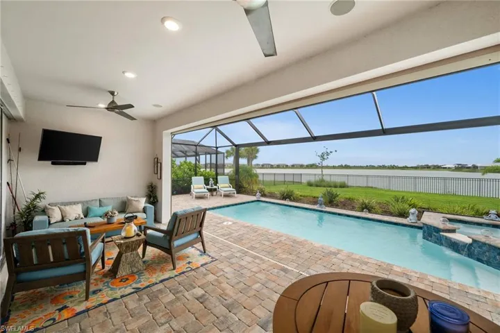 View of swimming pool with a water view, a patio area, an outdoor living space, ceiling fan, and a pool with connected hot tub