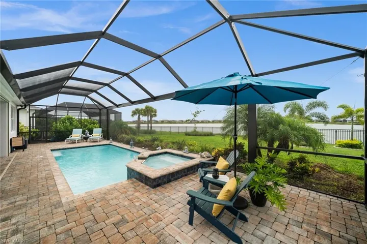 View of pool with a patio, a lanai, and a pool with connected hot tub