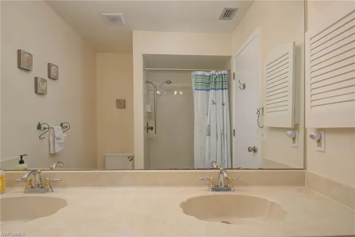 Bathroom with vanity, toilet, and a shower with shower curtain