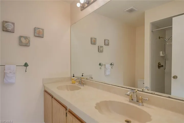 Bathroom with vanity, walk in shower, and toilet