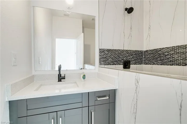 Dual tone kitchen with light stone countertops and two tone cabinetry