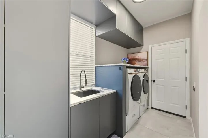 Laundry area with a sink and washer and clothes dryer