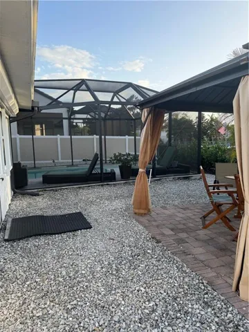 Fenced backyard with a patio, a sunroom, a lanai, and a swimming pool