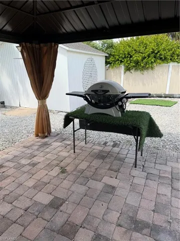 View of patio with a grill