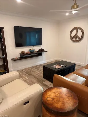 Living area featuring wood finished floors and crown molding