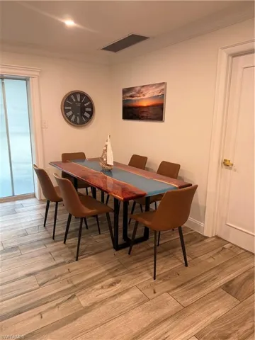 Dining area with ornamental molding and light wood-style flooring