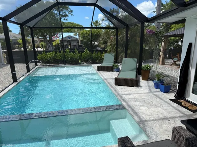 Relaxing pool / spa featuring a sunroom, a lanai, and a patio
