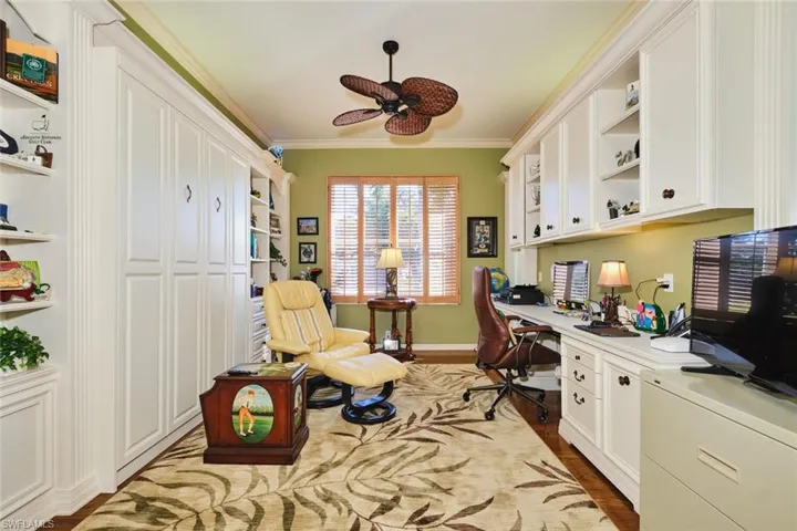 Office area featuring ornamental molding, built in study area, light wood-style flooring, and ceiling fan