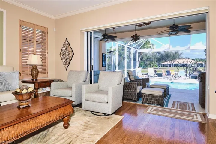 Living area featuring crown molding, wood finished floors, a sunroom, and ceiling fan