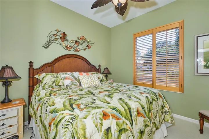 Carpeted bedroom with baseboards and a ceiling fan