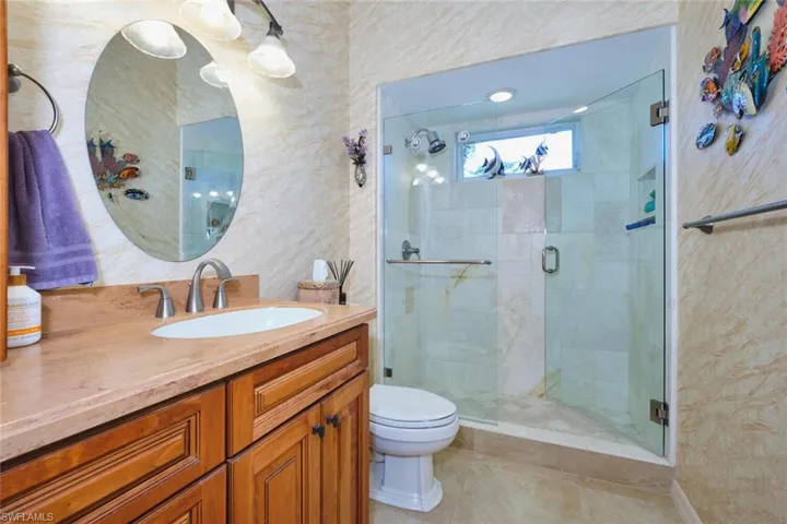 Bathroom with a stall shower, vanity, and light tile patterned flooring