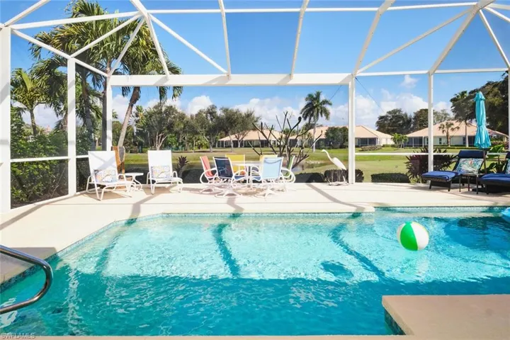 Outdoor pool with glass enclosure, a patio area, and a sunroom