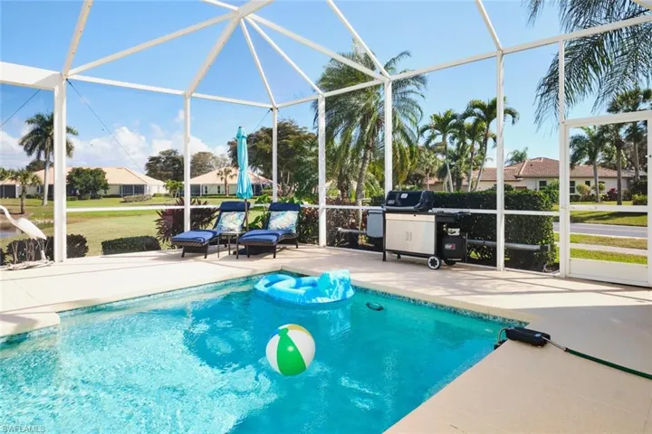 Swimming pool featuring a lanai, a sunroom, grilling area, and a patio area