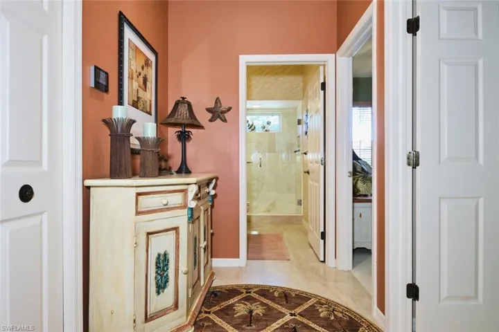 Hallway with inlaid floor details and light tile patterned flooring