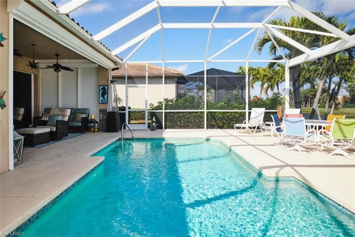 Outdoor pool featuring a patio area, a sunroom, glass enclosure, and outdoor furniture