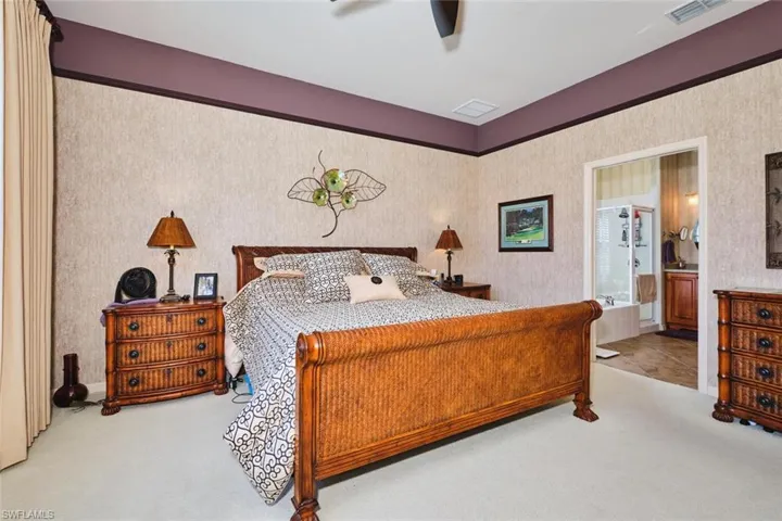 Bedroom featuring carpet flooring, a ceiling fan, and ensuite bath