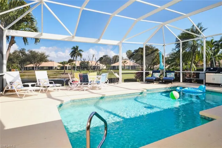Swimming pool with glass enclosure, a patio, a sunroom, and a residential view
