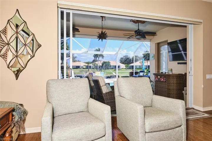 Sitting room with a sunroom, a ceiling fan, and wood finished floors