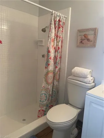 Full bathroom featuring a stall shower, vanity, and toilet