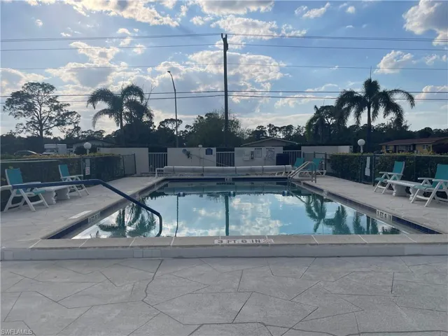 Pool with a patio area and fence