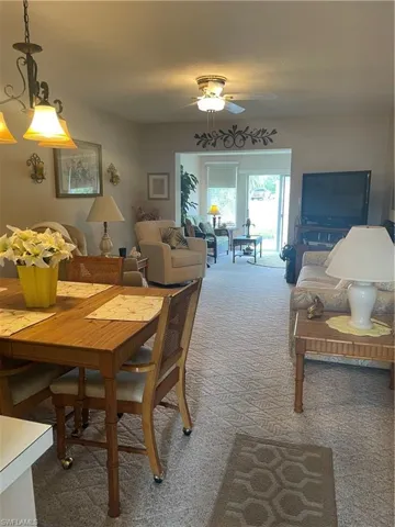 Carpeted dining area featuring ceiling fan and a textured ceiling