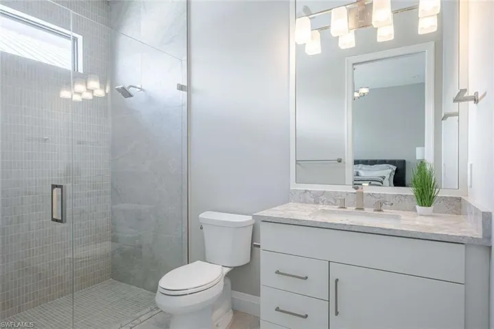 Ensuite bathroom featuring vanity, a shower stall, and toilet