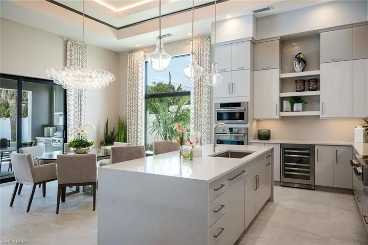 Kitchen featuring wine cooler, open shelves, modern cabinets, light countertops, and a chandelier