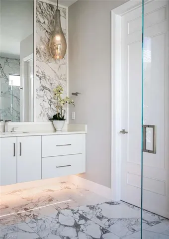 Bathroom featuring marble finish flooring, vanity, and baseboards