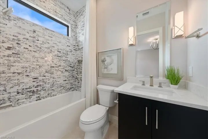 Full bath with toilet, vanity, shower / tub combo with curtain, and tile patterned flooring