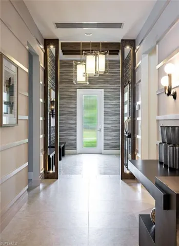 Foyer featuring wallpapered walls, french doors, an accent wall, and baseboards