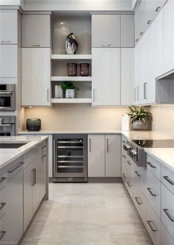 Kitchen featuring wine cooler, gray cabinets, open shelves, and tasteful backsplash