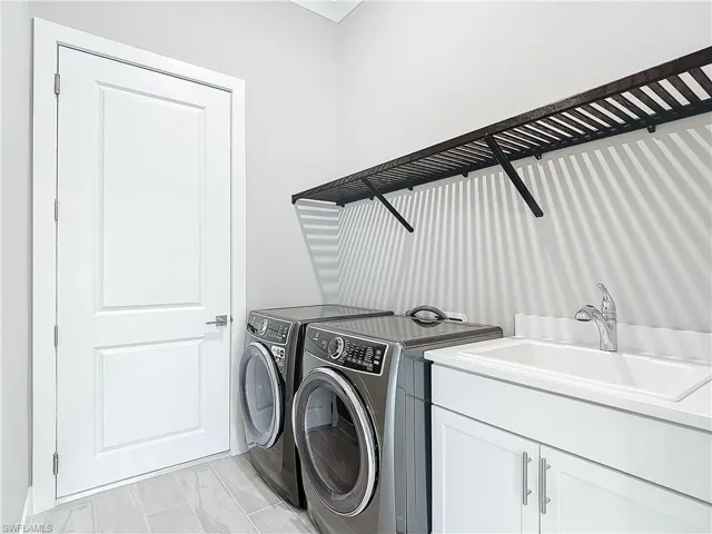 Laundry room with cabinets, sink, and washing machine and dryer