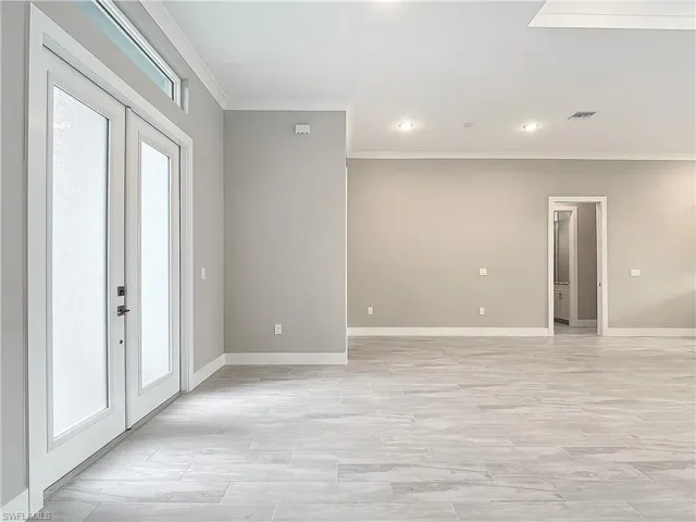 Spare room featuring crown molding and light hardwood / wood-style floors