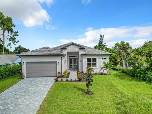 View of front of property featuring a garage and a front lawn